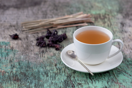 A cup of hot herbal tea on the old wooden background. Cup of tea herbal tea hot drink vintage texture background with copy spaceの写真素材
