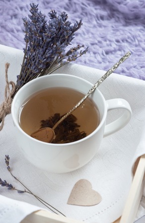 A tray with a cup of hot tea and lavender love letter in bed. Herbal tea Hot drink Mood Love Message Breakfast in bed Morning Lifestyleの写真素材