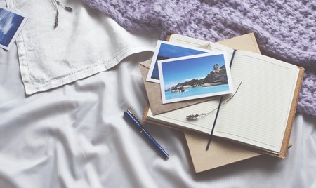 Notepad letter photo travel and book on white textile in bed. Diary Envelope Lifestyle Plaid Scarf Lavender Toning Cozy backgroundの写真素材
