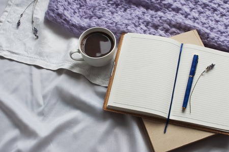 Notepad is a cup of coffee and a book with beige toning. Diary Lifestyle Plaid Scarf Lavender Toning Cozy backgroundの写真素材