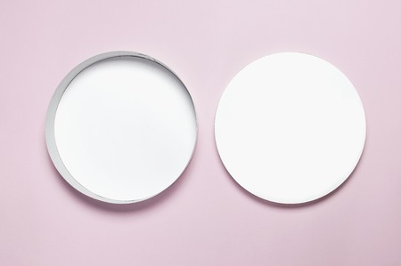 Round white cardboard blank box top view flat lay. Mock up on pink background. Packaging design, an empty box for shopping. mockup for designの写真素材