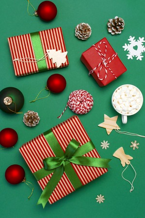 Gift boxes, Christmas balls, toys, fir cones, ribbon on green background. Festive, congratulation, New Year Christmas presents Xmas holiday 2019 greeting card. Flat lay, top view copy space.の写真素材