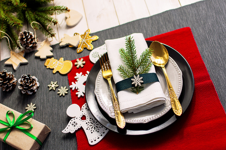 Christmas serving table. Traditional festive decoration background top view. Cutlery utensils beautiful plates decorative elements spruce branch. New Yearの写真素材