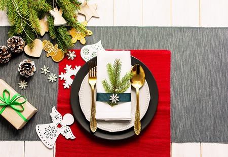 Christmas serving table. Traditional festive decoration background top view. Cutlery utensils beautiful plates decorative elements spruce branch. New Yearの写真素材