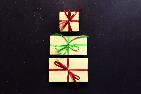 Traditional Christmas dark background top view. New Years gifts with red and green ribbon. Traditional festive decorationの写真素材