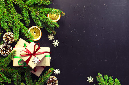 Traditional Christmas dark background top view. New Year composition Spruce branch Pine cone...