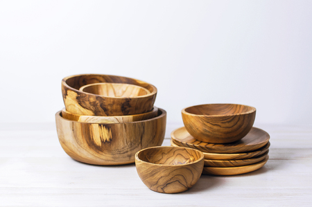 Wooden utensils for the kitchen, bowls and plates on a light background. The concept of natural dishes, a healthy lifestyle. Texture of wood.の写真素材