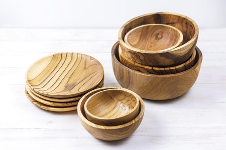 Wooden utensils for the kitchen, bowls and plates on a light background. The concept of natural dishes, a healthy lifestyle. Texture of wood.の写真素材