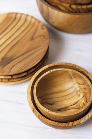 Wooden utensils for the kitchen, bowls and plates on a light background. The concept of natural dishes, a healthy lifestyle. Texture of wood.の写真素材