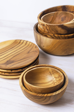 Wooden utensils for the kitchen, bowls and plates on a light background. The concept of natural dishes, a healthy lifestyle. Texture of wood.の写真素材