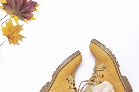 Female orange fashion shoes boots with autumn leaves on white background top view flat lay Fashion Lady Footwear Set Trendy Autumn accessories Female fashion lookの写真素材