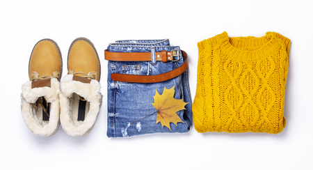 Female orange knitted sweater, blue jeans, boots and autumn leaves on green background top view flat lay Fashion Lady Clothes Set Trendy Cozy Knit Jumper Autumn accessories Female fashion lookの写真素材