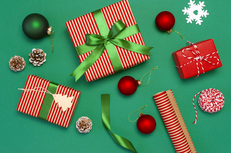 Gift boxes, Christmas balls, toys, fir cones, ribbon on green background. Festive, congratulation, New Year Christmas presents Xmas holiday 2019 greeting card. Flat lay top view, copy space.の写真素材