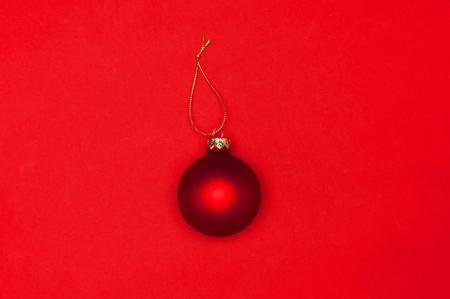 Red Christmas ball on red background Flat lay top view copy space. Christmas winter decoration Xmas holiday. Congratulations background New Year conceptの写真素材