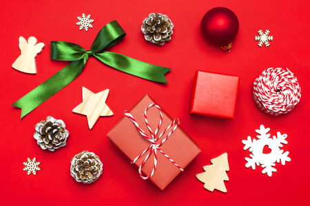 Christmas composition. New Year's wooden toys, fir cones, red ball, snowflake, gift twine on red background Flat lay top view copy space. Christmas winter decoration Nature New Year conceptの写真素材
