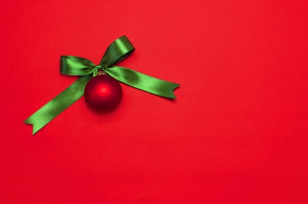 Red Christmas ball on red background Flat lay top view copy space. Christmas winter decoration Xmas holiday. Congratulations background New Year conceptの写真素材