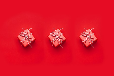 Three red gift box with decorative lace on red background top view flat lay. Holiday concept new year or Christmas gift box presents Xmas holiday. Congratulations background with space for textの写真素材