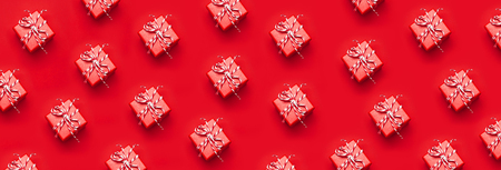 Pattern red gift box with decorative lace on red background top view flat lay. Holiday concept new year or Christmas gift box presents Xmas holiday Congratulations backgroundの写真素材
