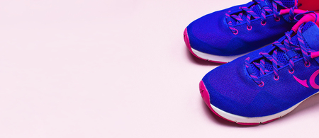 Ultra blue violet pink female sneakers on pastel pink background flat lay top view with copy space. Sports shoes, fitness, concept of healthy lifestile everyday training.の写真素材