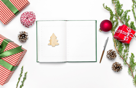 Open notebook with blank pages, gift boxes, fir branches on white background flat lay top view. Christmas planning concept Holiday decorations 2019 Goals. New Year, Christmas winter decorationの写真素材