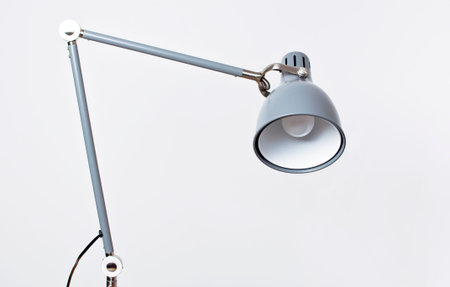 A gray table lamp in the interior against a white wall. The concept of business or education with a place for your text. Detail of interior minimalism background.の写真素材