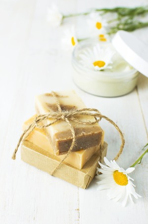 Natural cosmetics, handmade soaps, face and body cream with chamomile flower on a light background. Spa concept organic cosmetic. Natural beauty productの写真素材