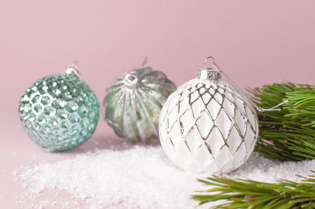 Vintage Christmas New Year balls in the snow and pine branches on pink background Flat Lay copy space. Holiday Baubles, beautiful Decoration Festive decor celebration Xmas holiday greeting cardの写真素材