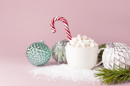 White mug with marshmallows Candy Cane Vintage Christmas New Year balls in the snow on pink background Flat Lay copy space. Winter traditional drink food Festive decor celebration holiday Baublesの写真素材