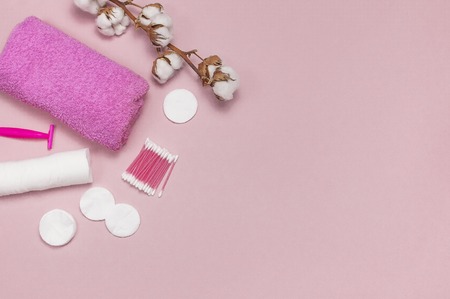 Spa concept. Flat lay background with cotton branch, cotton pads, eared sticks, pink towel. Cotton Cosmetic Makeup Removers Tampons Hygienic sanitary swabs on the pink background Top view copy spaceの写真素材