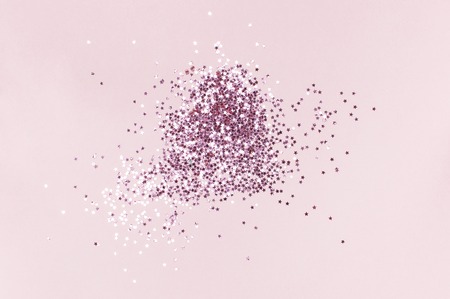 Pink holographic glitter confetti in the form of stars on pink background Flat lay top view copy space. Festive holiday pastel backdrop. Birthday, congratulations Christmas, New Yearの写真素材