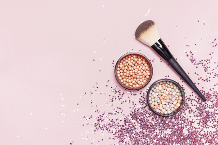 Different Cosmetic makeup brushes, blush powder balls and holographic glitter confetti in the form of stars on pink background Flat lay top view copy space Makeup accessories holiday birthday newyearの写真素材