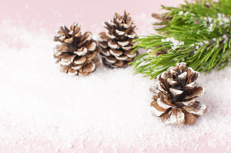 Christmas background, green pine branches, cones decorated with snow on snowy pink background. Creative composition with border and copy space design. New Year's, holiday, christmas decorationの写真素材
