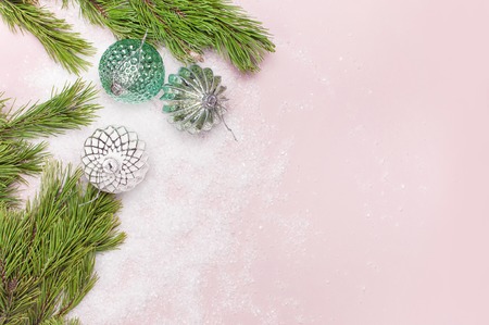 Vintage Christmas New Year balls in the snow and pine branches on pink background Flat Lay copy space. Holiday Baubles, beautiful Decoration Festive decor celebration Xmas holiday greeting cardの写真素材