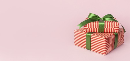 Gift boxes with green ribbon on pink background flat lay. Holiday concept, new year or Christmas gift box, presents Xmas holiday Congratulations background with space for text.の写真素材
