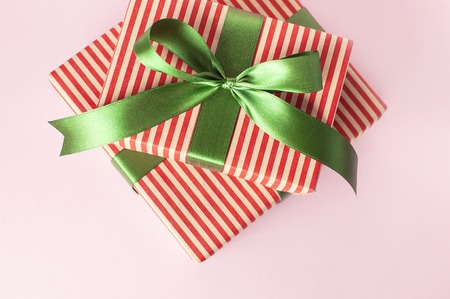 Gift boxes with green ribbon on pink background top view flat lay. Holiday concept, new year or Christmas gift box, presents Xmas holiday Congratulations background with space for text.の写真素材