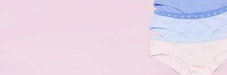 Female pastel cotton set panties on pink background top view flat lay with copy space for text. Fashion blog, Colorful women's natural underwear, advertising shopping concept.の写真素材