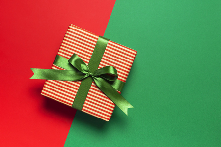 Gift boxes with green ribbon on red green background top view flat lay. Holiday concept, new year Christmas gift, presents birthday valentine's day Xmas Congratulations Festive background copy spaceの写真素材