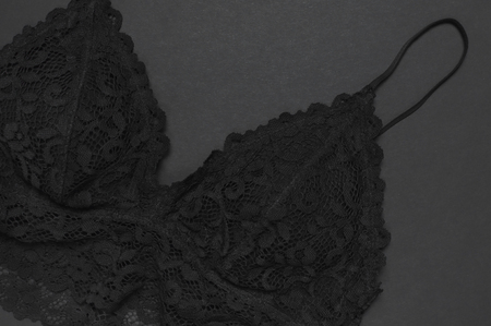 Black lace bra underwear on dark background top view flat lay with copy space. Female essential erotic clothes, fashionable beautiful underwear. Concept of sale in the store, shoppingの写真素材