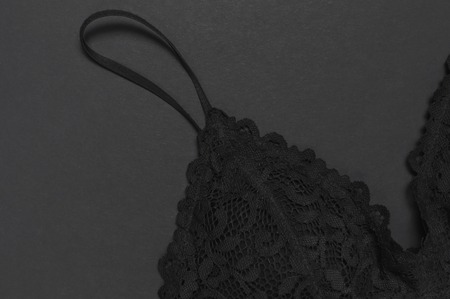 Black lace bra underwear on dark background top view flat lay with copy space. Female essential erotic clothes, fashionable beautiful underwear. Concept of sale in the store, shoppingの写真素材