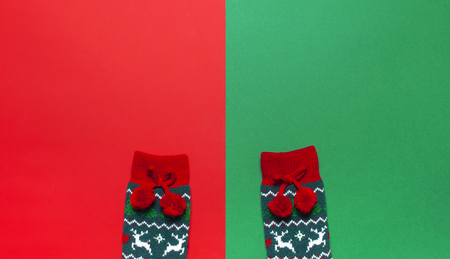 Woolen socks with a Christmas New Year ornament on red green background top view flat lay. Holiday concept, Festive socks, presents Xmas. Congratulations background with space for textの写真素材