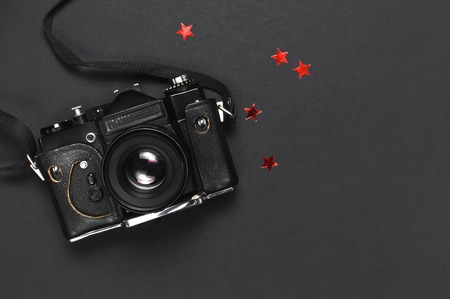 Old retro vintage camera in a leather case on black background top view flat lay with copy space. Concept for the photographer, old photographic equipment minimalistic style selective focusの写真素材