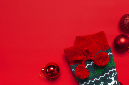 Woolen socks with a Christmas New Year ornament on red background top view flat lay. Holiday concept, Festive socks, presents Xmas. Congratulations background with space for text Clothes for the coldの写真素材