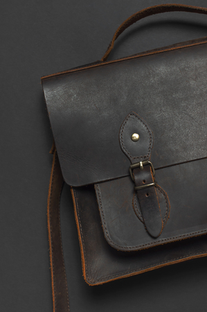 Fashionable concept. Brown leather men's bag on black background top view flat lay with copy space. Briefcase for work, Accessories businessman, stylish men's clothes, business backgroundの写真素材