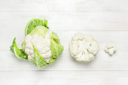 Fresh raw cauliflower on rustic white wooden background top view flat lay copy space. Cooking, healthy wholesome food, vegetable, diet conceptの写真素材