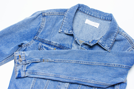 Close-up Blue denim jacket on isolated white background top view flat lay copy space. Denim, fashionable jacket, womens or mens trend clothing, fashion backgroundの写真素材