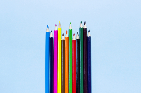 Color pencils on blue background top view flat lay with copy space. Wooden colored pencils for drawing, objects for creativity, school supplies close-up. Back to school conceptの写真素材
