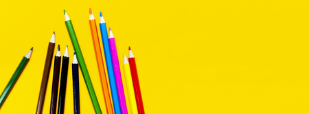 Color pencils on bright yellow background top view flat lay with copy space. Wooden colored pencils for drawing, objects for creativity, school supplies close-up. Back to school conceptの写真素材