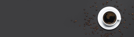 Flat lay cup of black coffee and coffee beans on gray dark background top view copy space. Minimalistic food concept, morning breakfast, time to work, hot drink coffee backgroundの写真素材