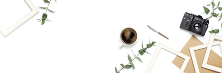 Photo frame old retro camera notebook diary cup of coffee pens eucalyptus leaves on white background. Flat lay top view copy space. Stylish minimal composition artwork mockup Feminine desk workspace.の写真素材