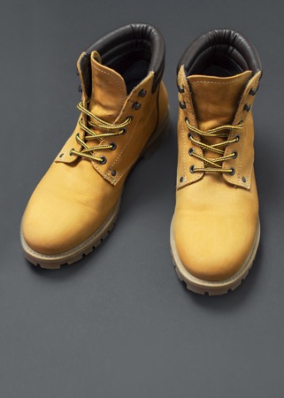 Yellow mens work boots from natural nubuck leather on gray black background. Trendy casual shoes, youth style. Concept of advertising autumn winter shoes, sale, shopの写真素材